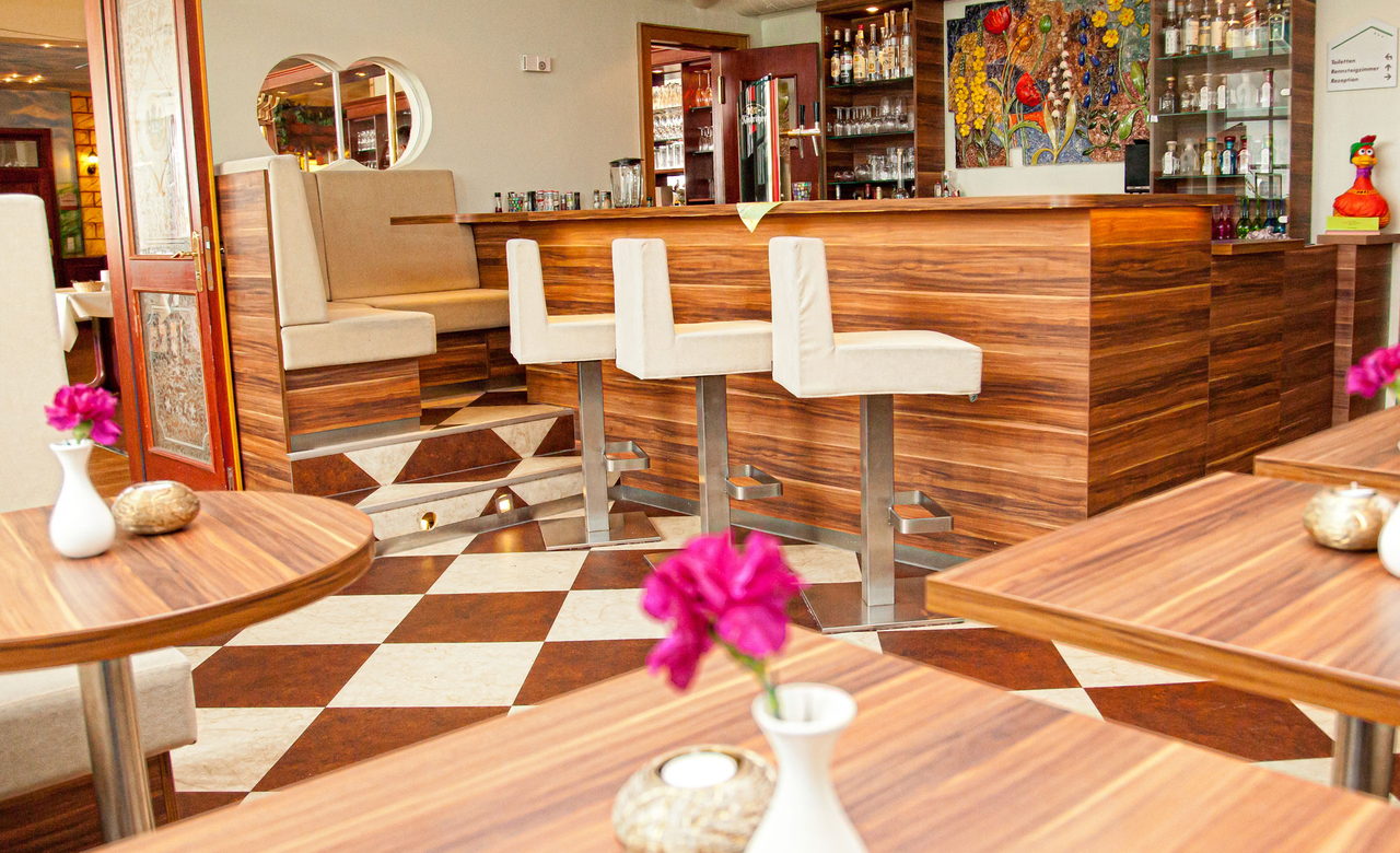 modern gestaltete Bar im Sporthotel Oberhof mit Blick auf den Tresen mit Barhockern und komfortablen Sitzbänken