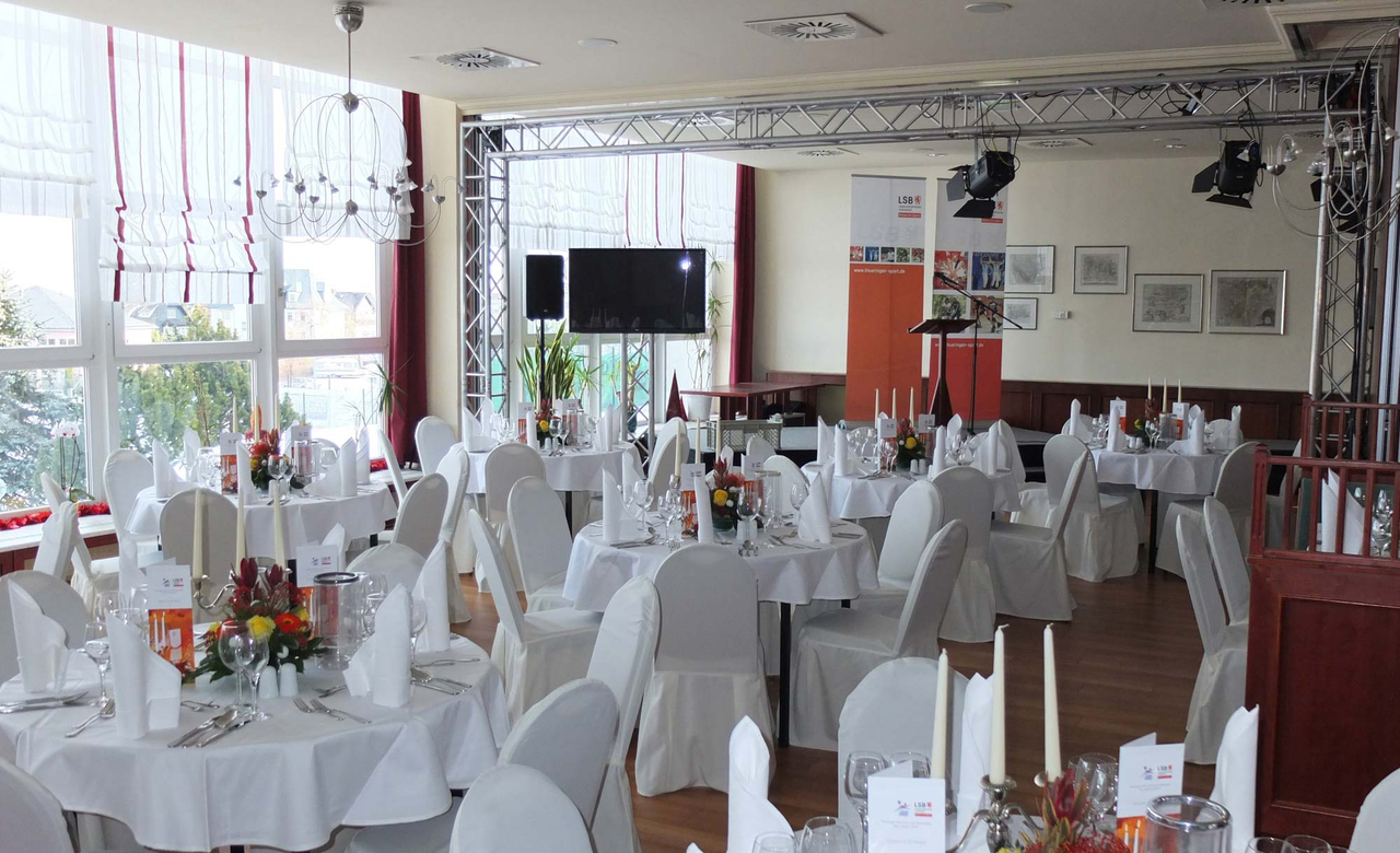 Festlich gestalteter Tagungsraum mit weiß eingekleideten Tischen und Stühlen für eine Veranstaltung im Sporthotel Oberhof