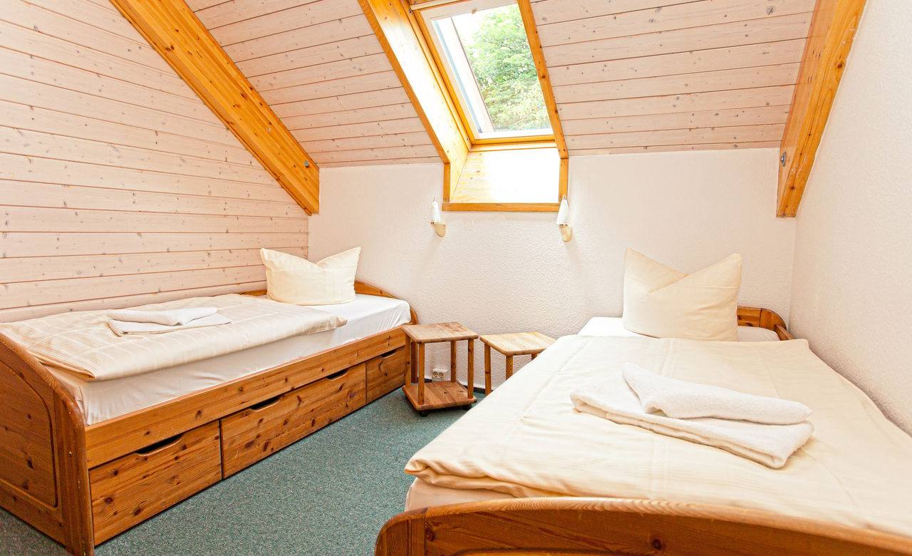 Schlafzimmer im Dachgeschoss eines Ferienhauses vom Sporthotel Oberhof mit zwei getrennten Einzelbetten