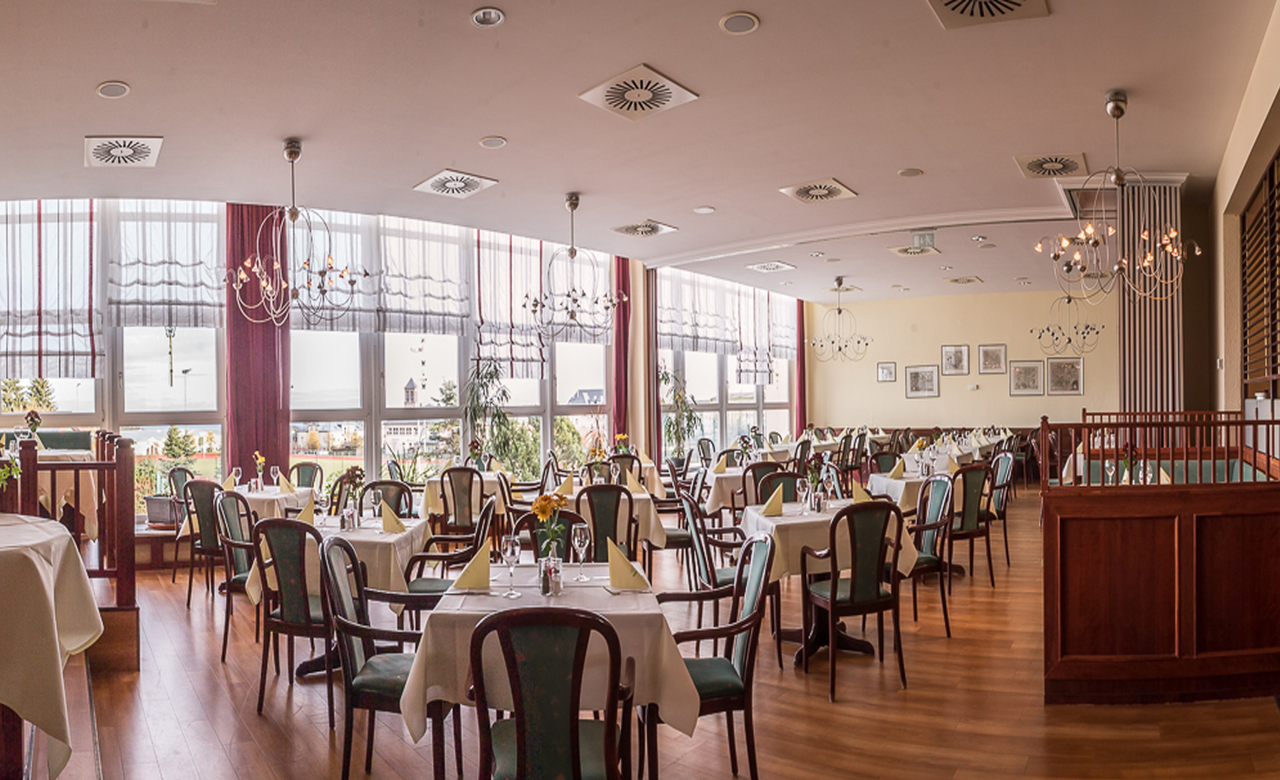 Helles Restaurant im Sporthotel Oberhof mit gedeckten Tischen und frischen Blumen