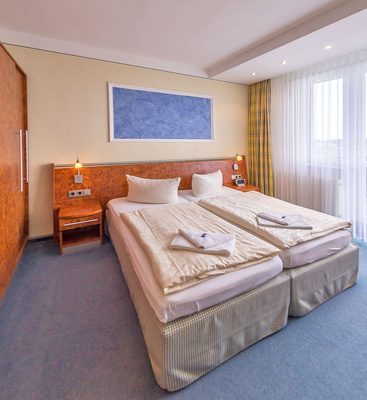 Schlafzimmer in einem Apartment im Sporthotel Oberhof mit komfortablem Doppelbett und großem Schrank