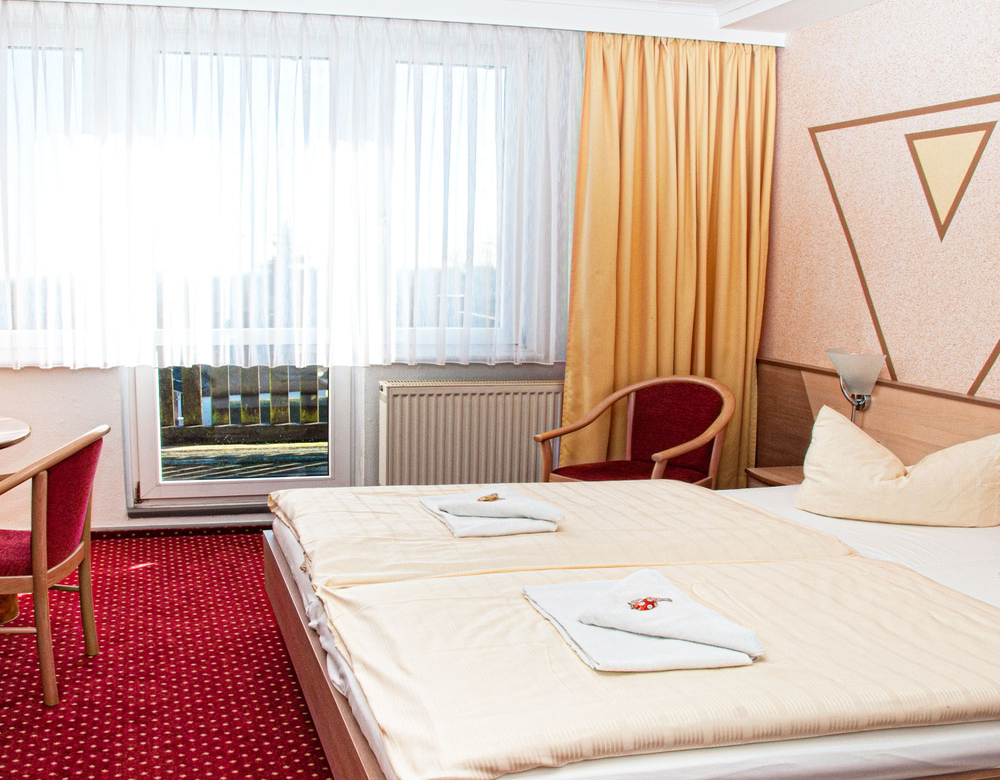 helles Komfort Zimmer im Sporthotel Oberhof mit komfortablem Doppelbett und Balkon