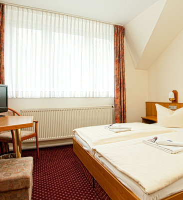 Standard Zimmer im Sporthotel Oberhof mit komfortablem Doppelbett, Schreibtisch und Fernseher